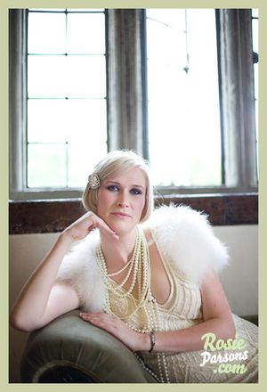 What a stunning bride, ostrich feather shrug, flapper style dress & miles of pearls....
